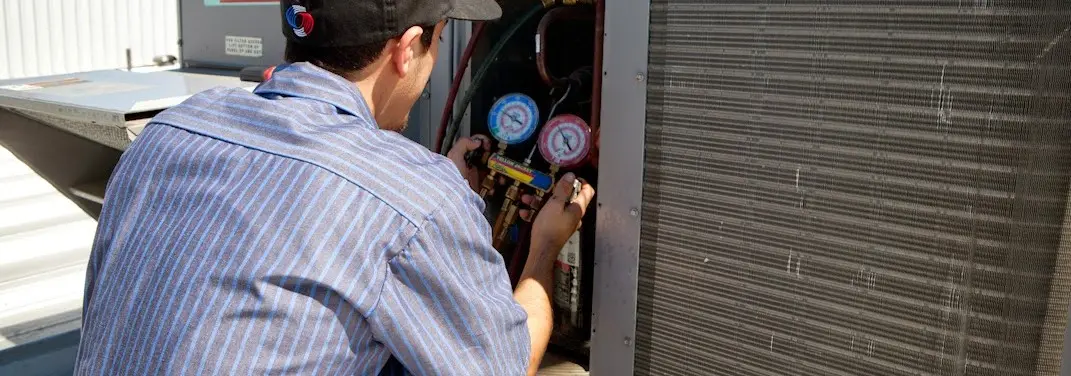 HVAC technician servicing a condenser unit in Molalla