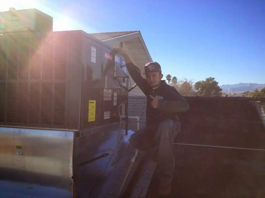 HVAC technician performing Boiler Repair on a rooftop unit in Molalla